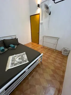 a room with a bed with a fan and a door at Santai DPermai Homestay in Selama