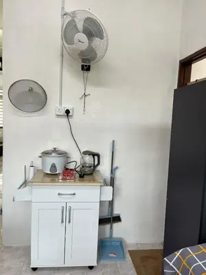 a kitchen with a white counter with a fan at Santai DPermai Homestay in Selama