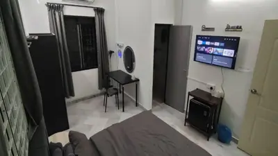 a living room with a flat screen tv and a desk at sunshine bnb concept service in Ipoh
