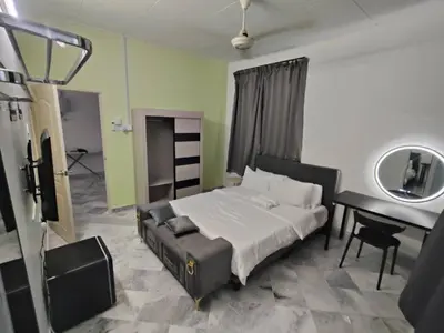 a bedroom with a bed and a desk and a mirror at sunshine bnb concept service in Ipoh