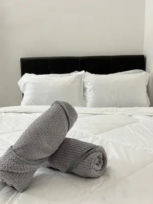 a knitted scarf laying on top of a bed at Silibin Family 4B3B Homestay 11pax by Iconique in Ipoh