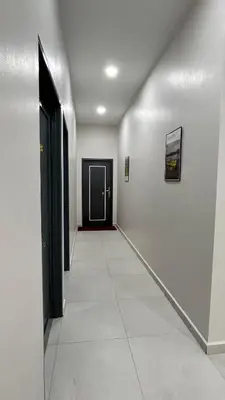 a hallway with white walls and a black door at Kuala Kubu Bharu Guesthouse Hotel in Kuala Kubu Baharu