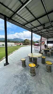 a group of tables and stools under a pavilion at Kuala Kubu Bharu Guesthouse Hotel in Kuala Kubu Baharu