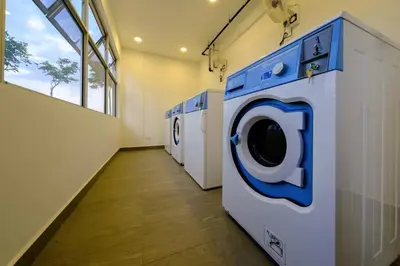a laundry room with a row of washing machines at Seaview Studio 2BR 3BR Tanjung Point Residences in Tanjong Tokong