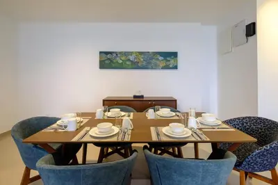 a dining room table with chairs and a wooden table at Seaview Studio 2BR 3BR Tanjung Point Residences in Tanjong Tokong