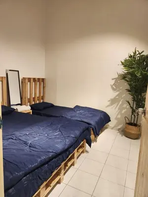 a bedroom with two beds and a potted plant at Sun Vista Home by Ipoh Maju Stay in Ipoh