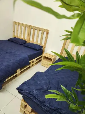 a bedroom with two beds with blue sheets and a plant at Sun Vista Home by Ipoh Maju Stay in Ipoh