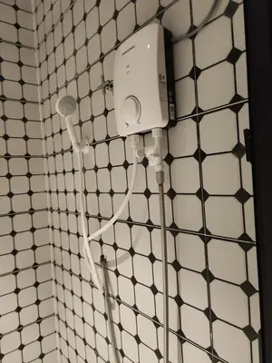 a bathroom with a shower with a hair dryer at Sun Vista Home by Ipoh Maju Stay in Ipoh