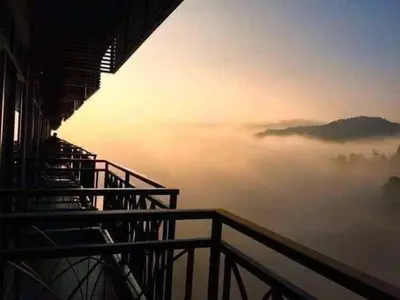 a view from a building of a foggy overlook with the sun rising in at Cameron Nova Highlands Resort VIII in Brinchang