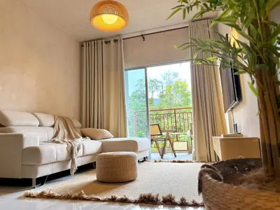 a living room with a white couch and a balcony at Asa and Mori Japandi, Emerald Avenue, Brinchang in Tanah Rata