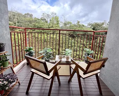 a balcony with a table and chairs on a balcony at Asa and Mori Japandi, Emerald Avenue, Brinchang in Tanah Rata