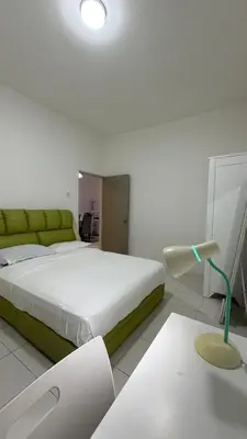 a bedroom with a large bed and a green couch at The White Mist Cameron in Tanah Rata