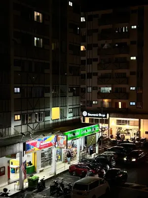 a parking lot with cars parked in a city at night at The White Mist Cameron in Tanah Rata