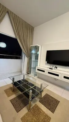 a living room with a glass table and a flat screen tv at The White Mist Cameron in Tanah Rata