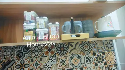 a shelf with cups and other items on it at Homestay Annur Hijrah Seri Iskandar Near UiTM ,UTP in Seri Iskandar