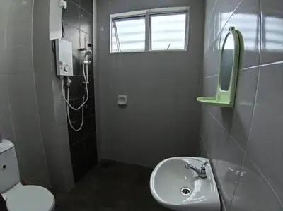 a bathroom with a sink and a mirror and a toilet at Raub Sutera Homestay in Kampong Sempalit Ulu