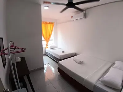 a hotel room with two beds and a window at Raub Sutera Homestay in Kampong Sempalit Ulu