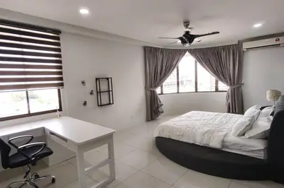 a bedroom with a bed and a desk and windows at RoomB w attached bathroom w bathtub in George Town