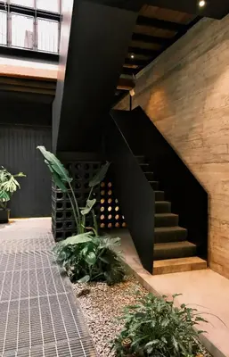 a black staircase in a building with plants at Playce Hotel in George Town