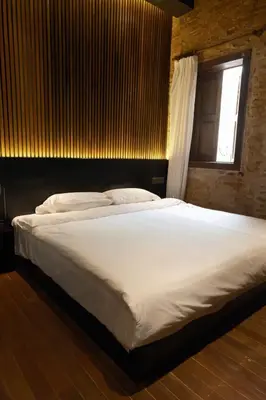 a large white bed in a room with a window at Playce Hotel in George Town