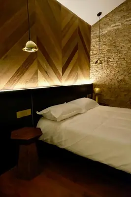 a bedroom with a white bed and a wooden wall at Playce Hotel in George Town