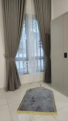 a rug on the floor in front of a window at Sofea Stay Homestay Sungai Petani in Sungai Petani