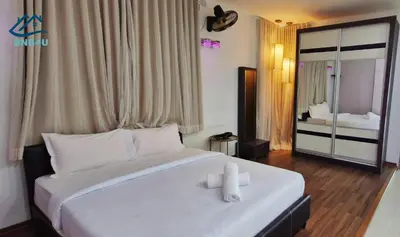 a bedroom with a large bed with white pillows at Landed Spacious House at Cangkat Delima Gelugor Penang in Gelugor