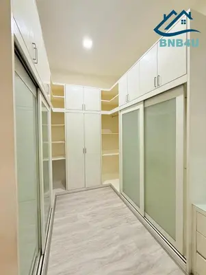 a walk in closet with white cabinets and shelves at Landed Spacious House at Cangkat Delima Gelugor Penang in Gelugor