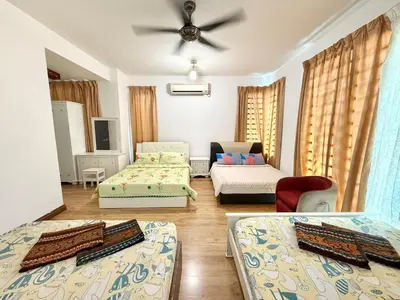 a living room with two beds and a couch at 7BR Penang Stay Near Gurney and George Town in Tanjong Tokong
