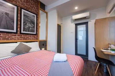 a bedroom with a bed and a brick wall at B Street Hotel in George Town