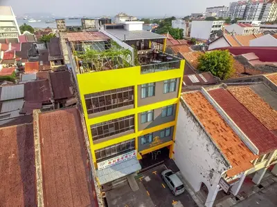 an overhead view of a yellow building in a city at B Street Hotel in George Town