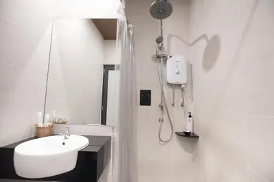 a white bathroom with a sink and a shower at B Street Hotel in George Town