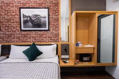 a bedroom with a bed and a brick wall at B Street Hotel in George Town