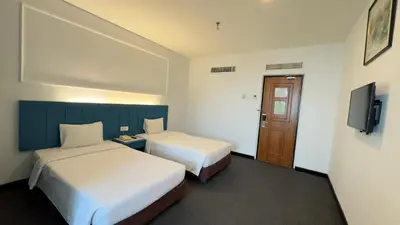 a hotel room with two beds and a television at Hotel Continental Penang in George Town