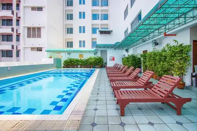 a row of red benches next to a swimming pool at Hotel Continental Penang in George Town