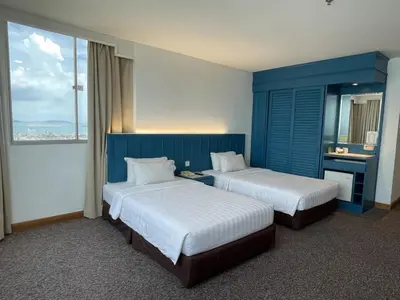 a hotel room with two beds and a window at Hotel Continental Penang in George Town
