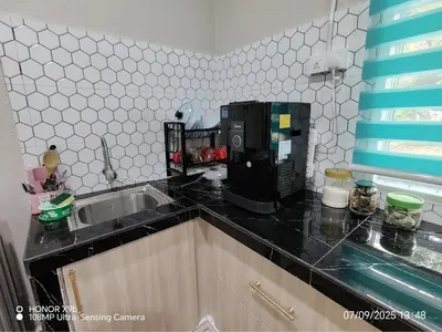 a kitchen counter with a sink and a microwave at Homestay Haji Omar Sungai Dua Butterworth in Kampong Lahar Yooi