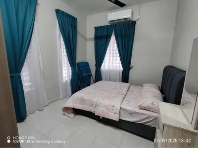 a bedroom with a bed with blue drapes at Homestay Haji Omar Sungai Dua Butterworth in Kampong Lahar Yooi