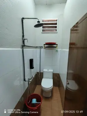 a small bathroom with a toilet and a shower at Homestay Haji Omar Sungai Dua Butterworth in Kampong Lahar Yooi