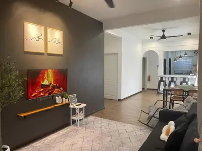 a living room with a fireplace on the wall at Hafiyya Raintown Homestay, Taiping in Taiping