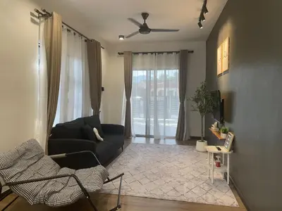 a living room with a couch and a ceiling fan at Hafiyya Raintown Homestay, Taiping in Taiping