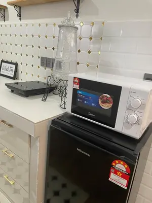 a microwave oven sitting on top of a dishwasher at Hafiyya Raintown Homestay, Taiping in Taiping