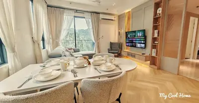 a living room with a table and chairs and a tv at Onsen Suite Theme Park View in Ipoh