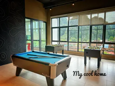 a pool table in the middle of a room with windows at Onsen Suite Theme Park View in Ipoh