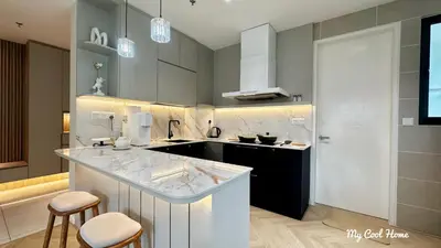 a kitchen with a counter and two stools in it at Onsen Suite Theme Park View in Ipoh