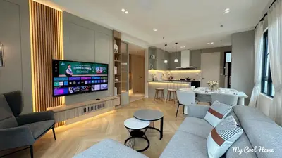 a living room with a couch and a tv and a kitchen at Onsen Suite Theme Park View in Ipoh