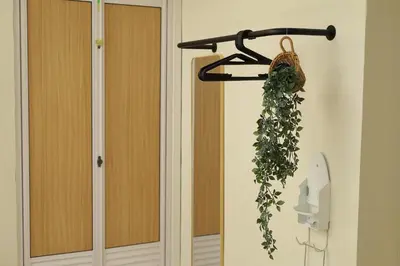 a plant hanging on a rack next to a door at Sarang A Cottage with private pool in Sungai Petani
