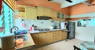 a kitchen with wooden cabinets and a stainless steel refrigerator at Afnaz Homestay Penang in Perai