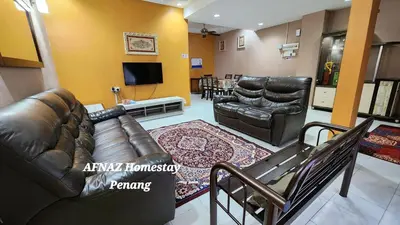 a living room with a leather couch and chairs at Afnaz Homestay Penang in Perai