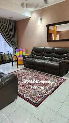 a living room with a black leather couch and a rug at Afnaz Homestay Penang in Perai